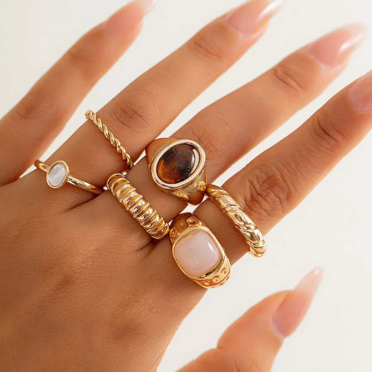 Six light gold geometric alloy rings with electroplated finish displayed together