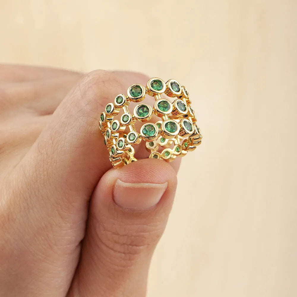 Gold-coloured wide ring with a textured three-layer exaggerated design on a plain background.