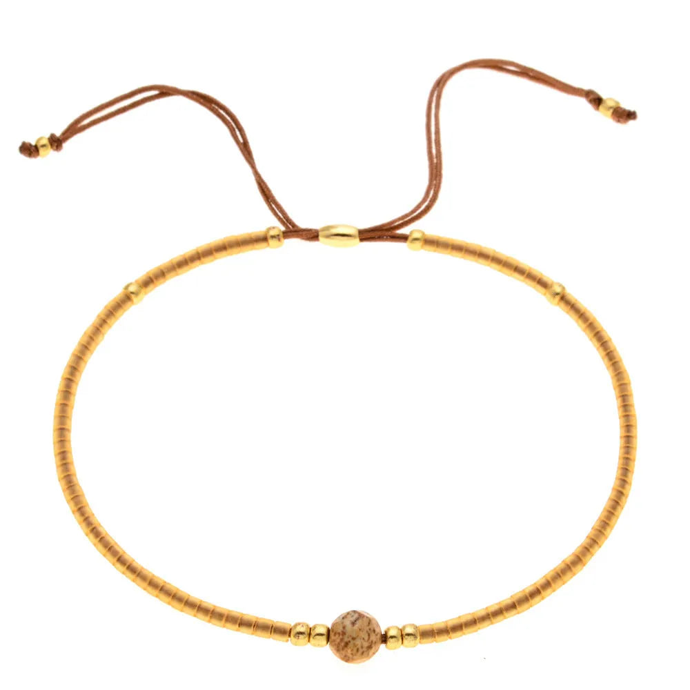 Handmade women's beaded bracelet with colourful glass and glaze beads in geometric bohemian style