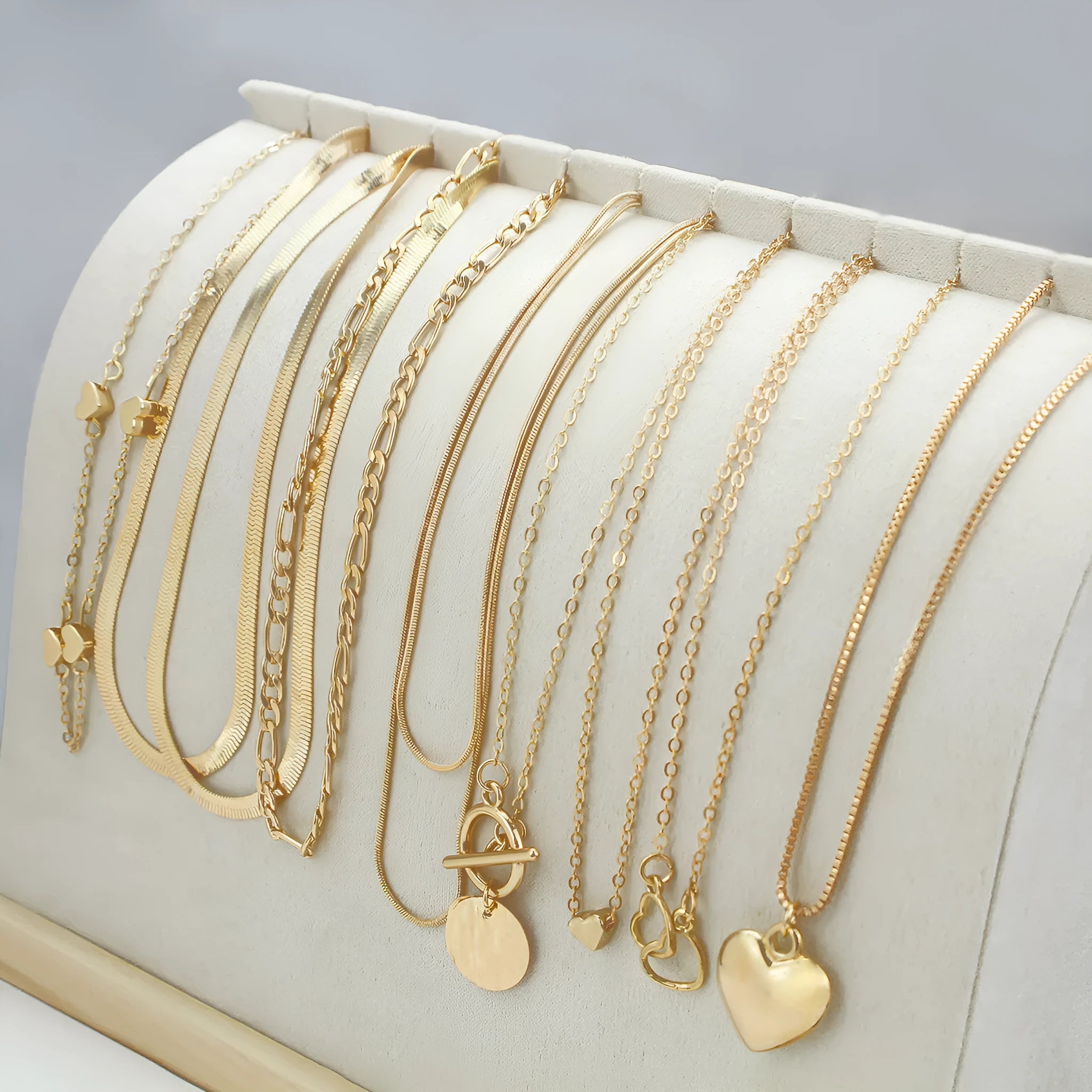 10 piece gold electroplated women's necklace set with adjustable chain length on display