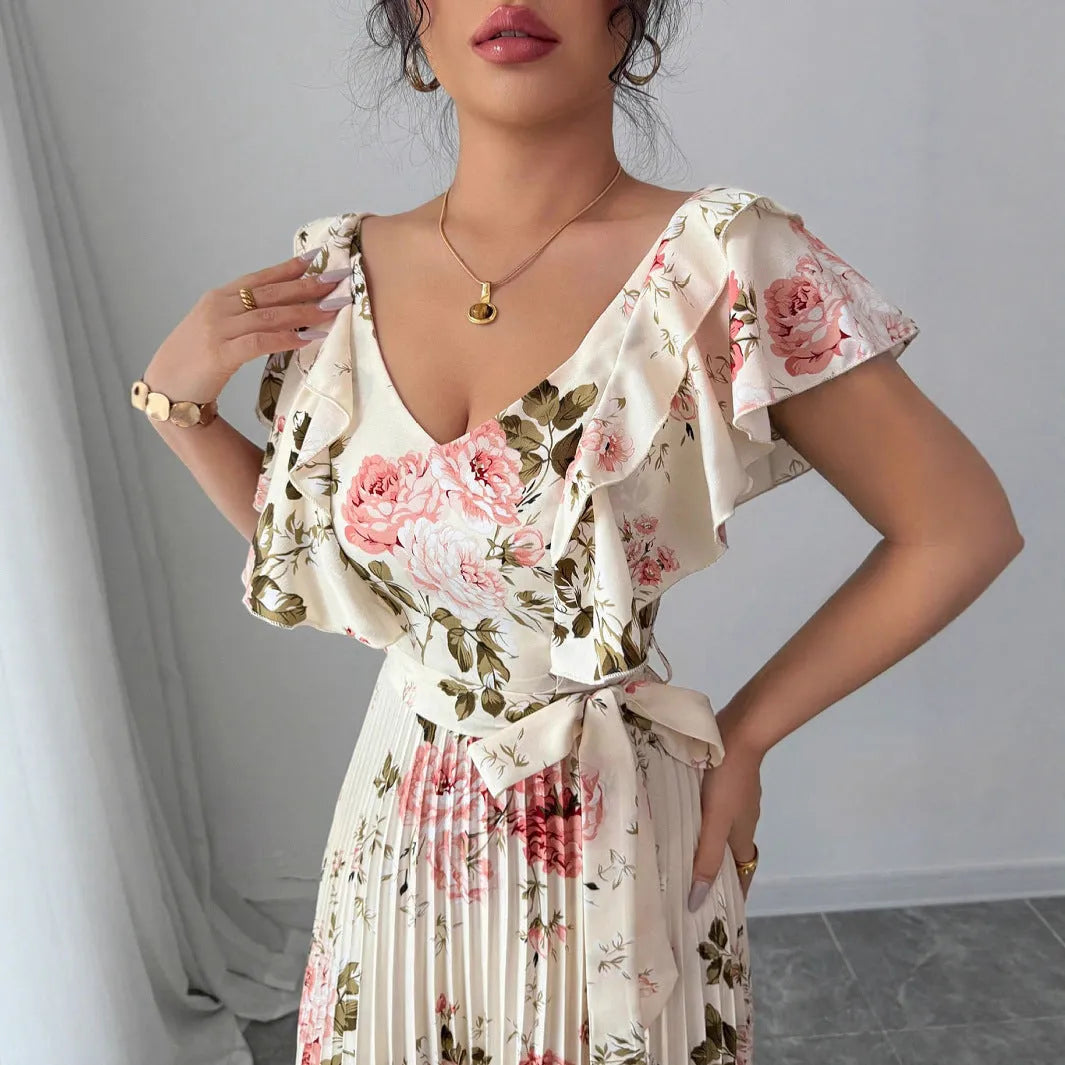 Apricot coloured floral print dress with a v-neck, ruffled short sleeves, and a long high-waisted swing skirt.