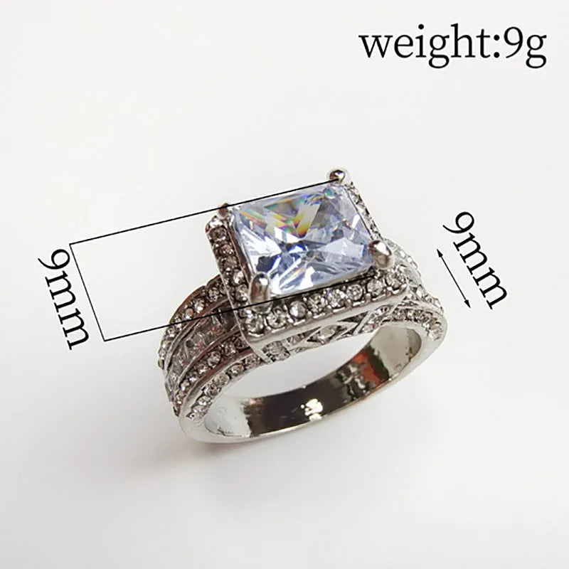 Women's silver geometric round ring in gold or white electroplated finish on a grey background