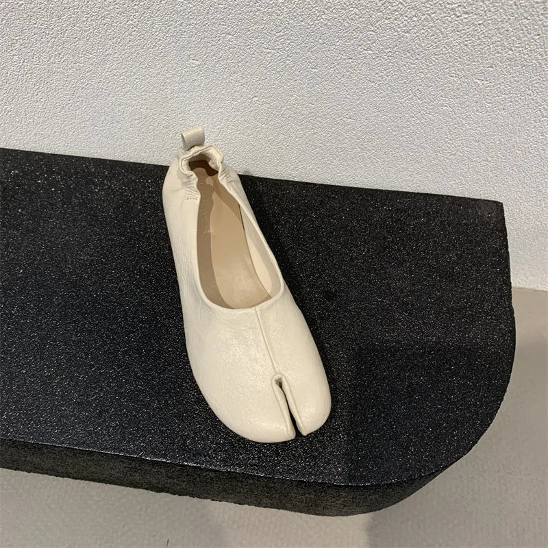 Women's brown split toe horseshoe design chunky heel pumps on a white background.