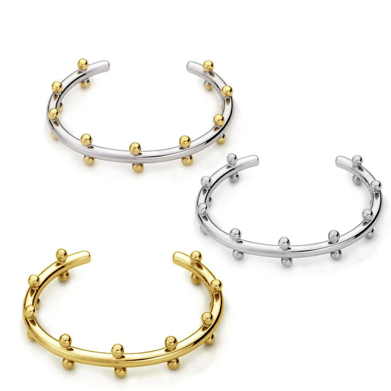Stainless steel C-shaped bracelet with textured rivet bean beads in gold or steel colour.
