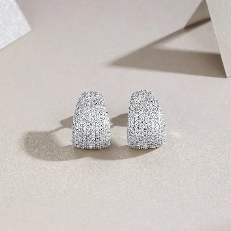 Geometric moissanite stud earrings with sterling silver posts on a gift box