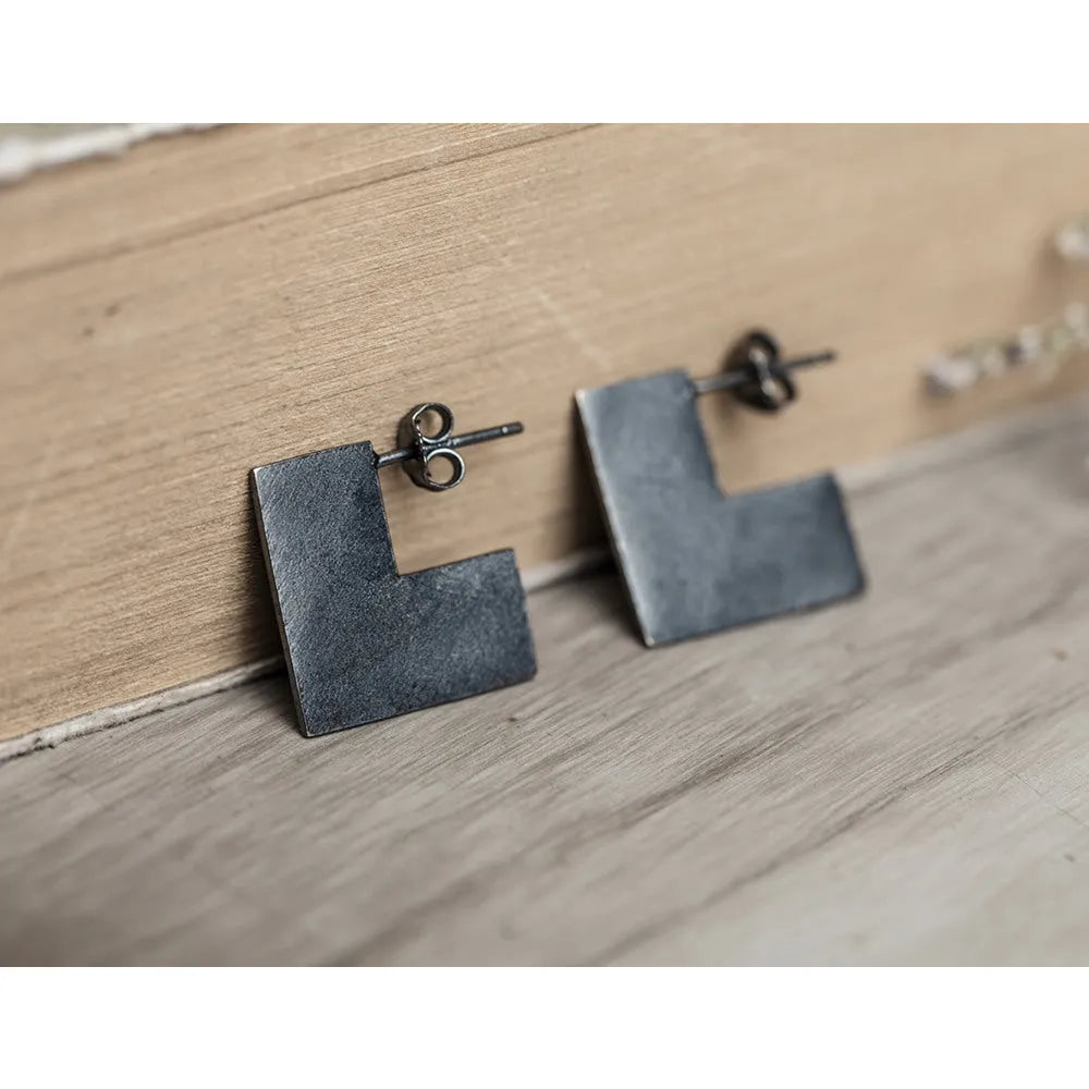 Square oxidised black sterling silver geometric earrings on a white background.