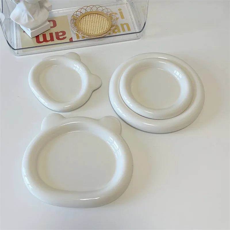 White porcelain plate with bear doodle design, shown as a plant pot tray.