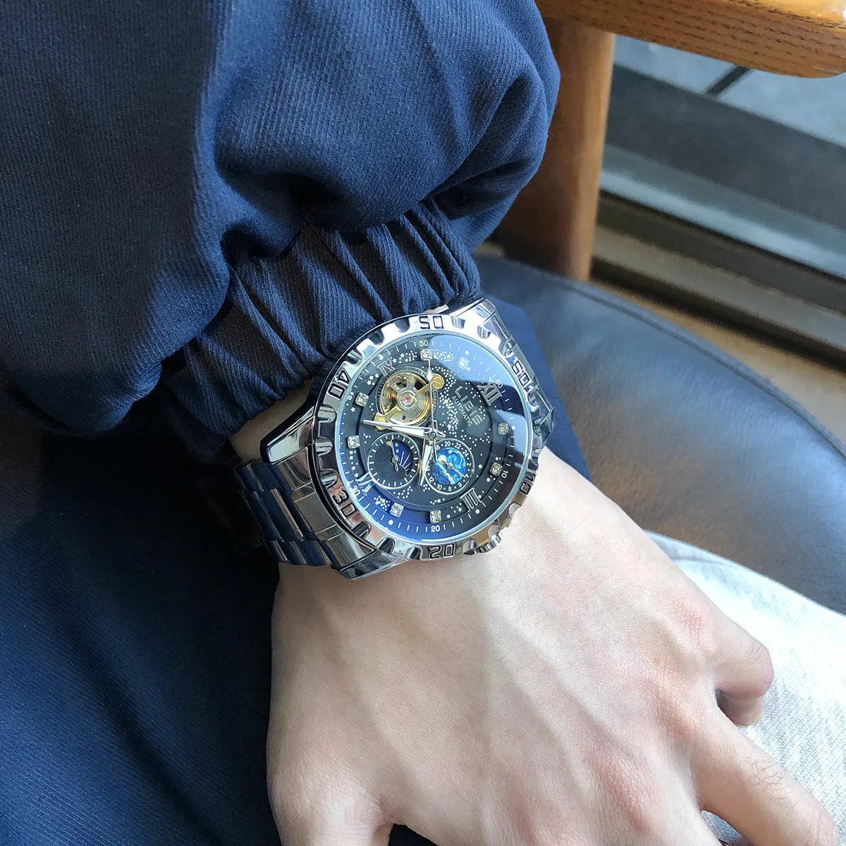 Men's silver automatic mechanical watch with black dial, luminous markers, and genuine leather strap