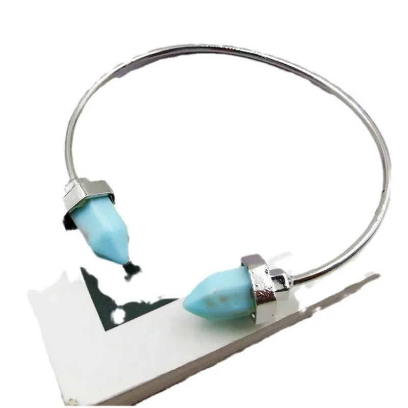 Natural alloy open-ended bracelet with inlaid gem turquoise style in silver blue finish on a neutral background