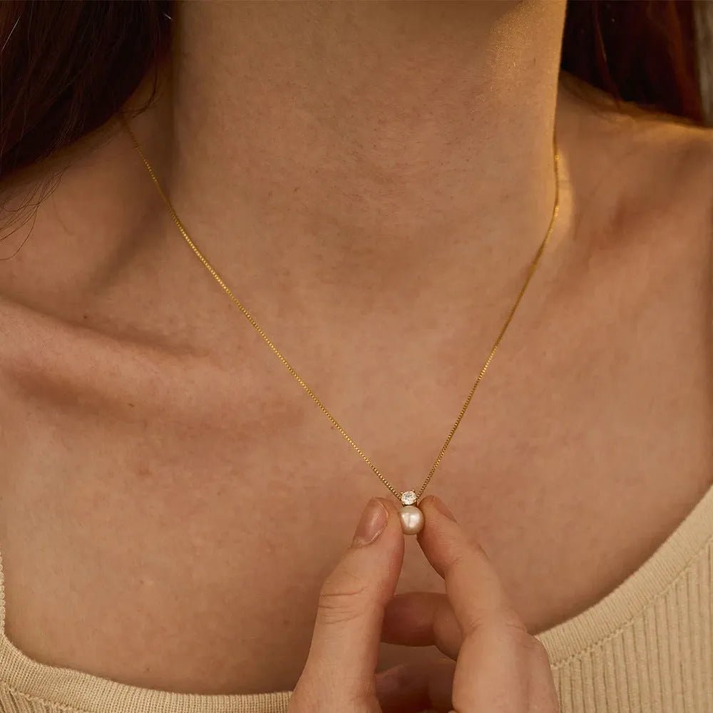 St Delan stainless steel necklace with imitation pearl and zircon pendant in gold colour.