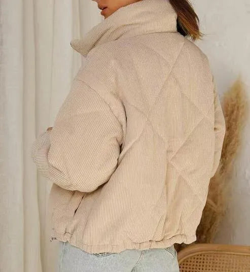 Women's apricot coloured corduroy jacket with a stand collar and front zipper on a hanger.