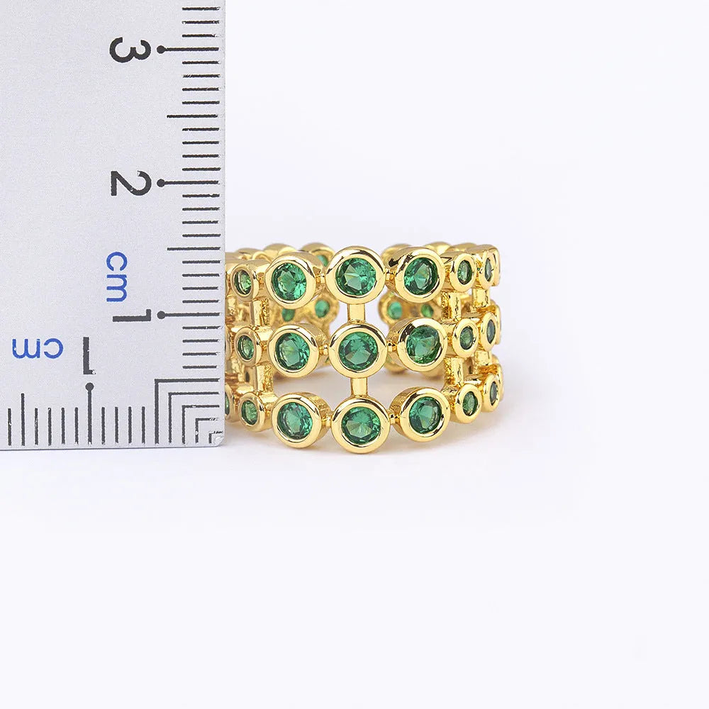 Gold-coloured wide ring with a textured three-layer exaggerated design on a plain background.