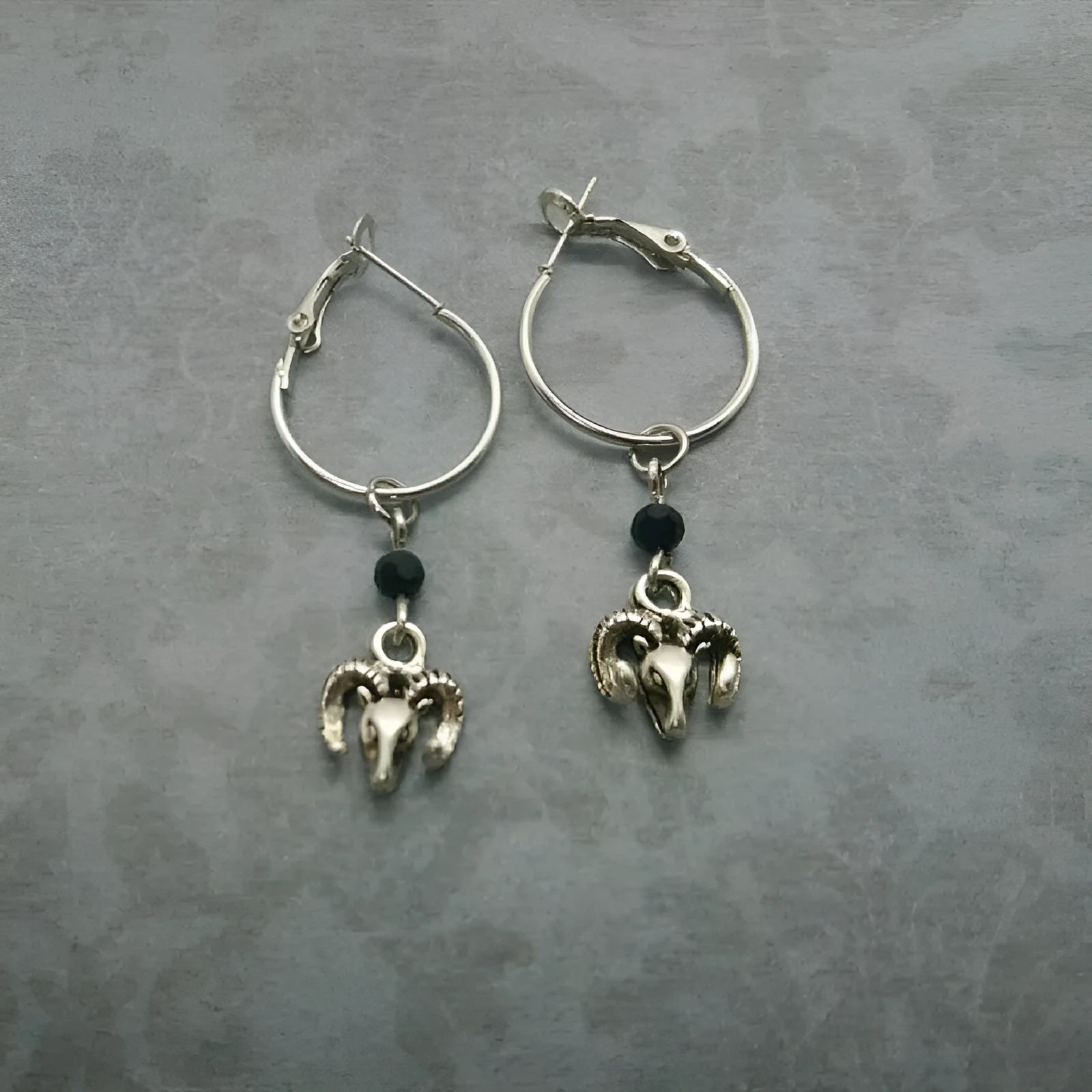 A pair of silver-coloured alloy round ring earrings for women featuring a Tibetan antelope design.