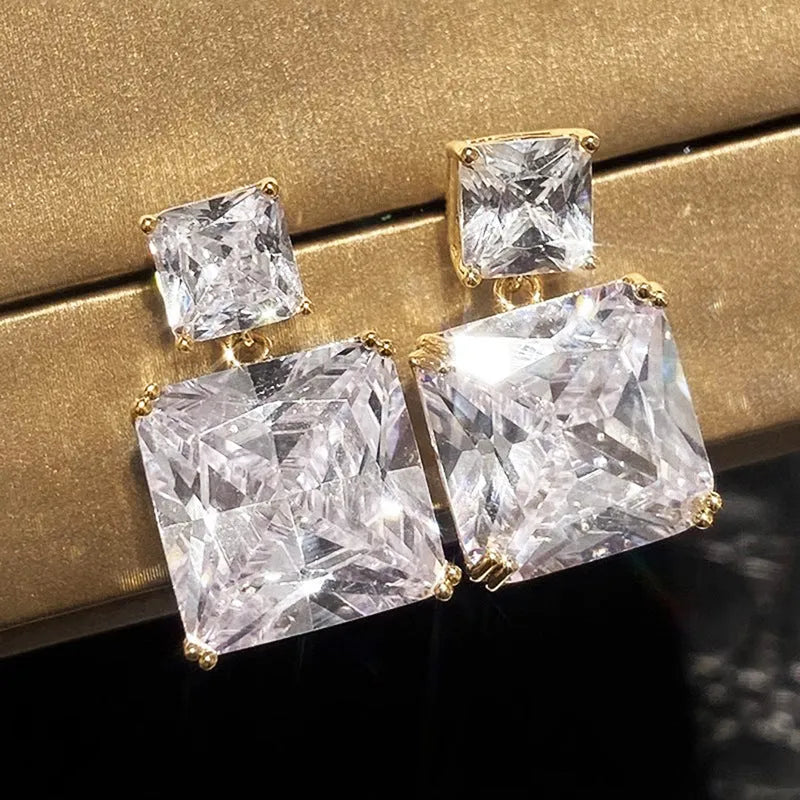 A pair of geometric square design copper earrings for women in gold and white gold colour options.