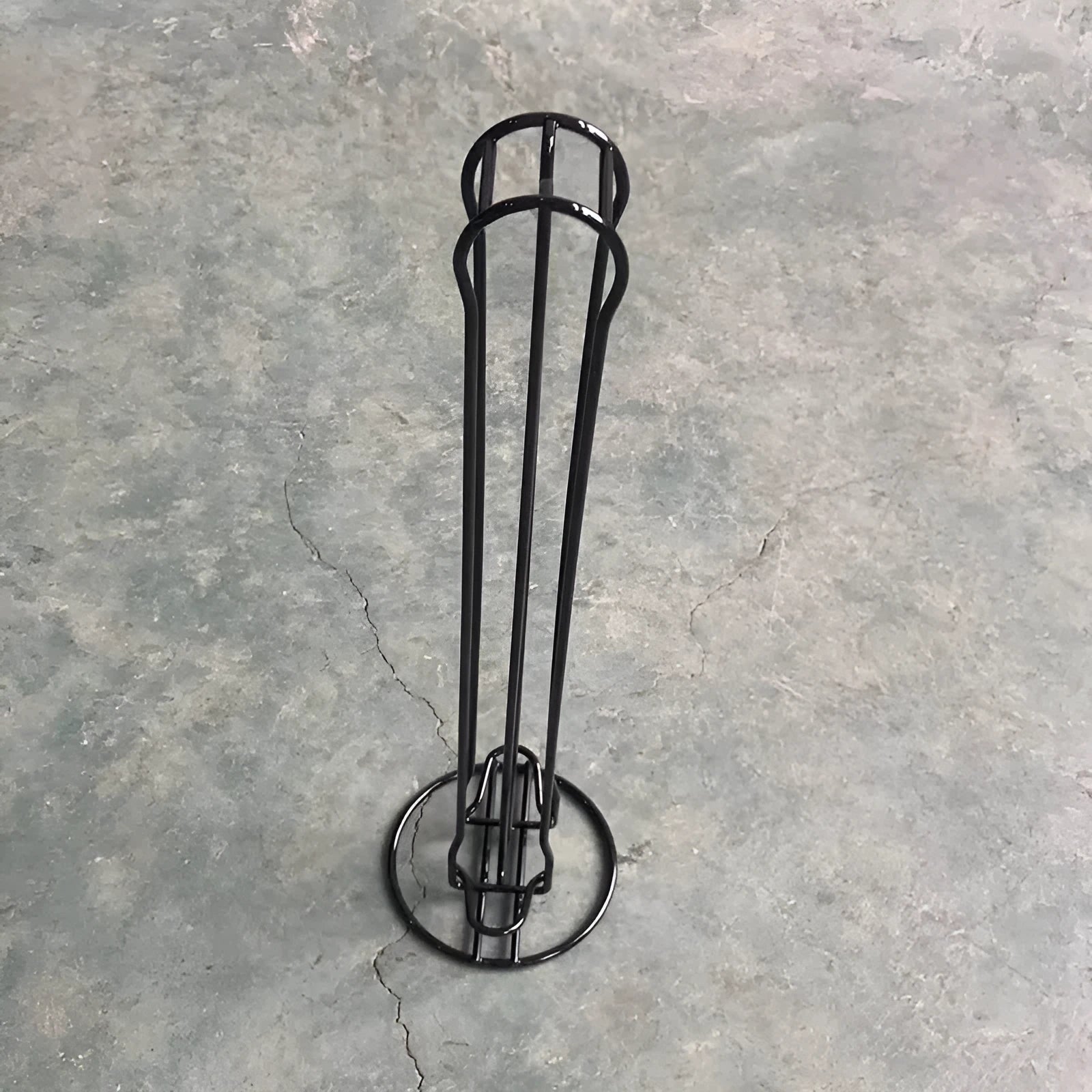 Wrought iron coffee capsule storage rack holding pods, in spray black finish.