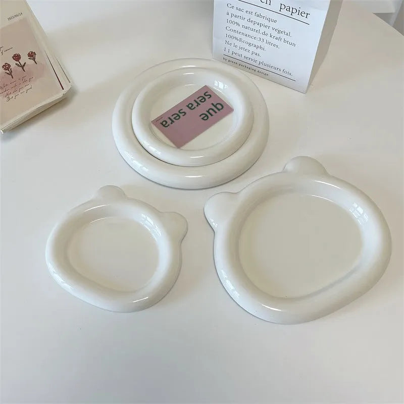 White porcelain plate with bear doodle design, shown as a plant pot tray.