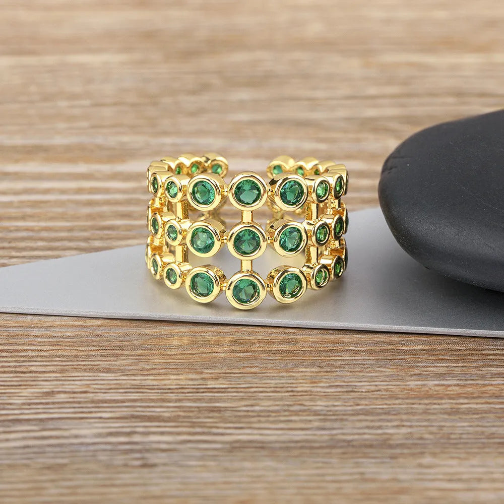 Gold-coloured wide ring with a textured three-layer exaggerated design on a plain background.