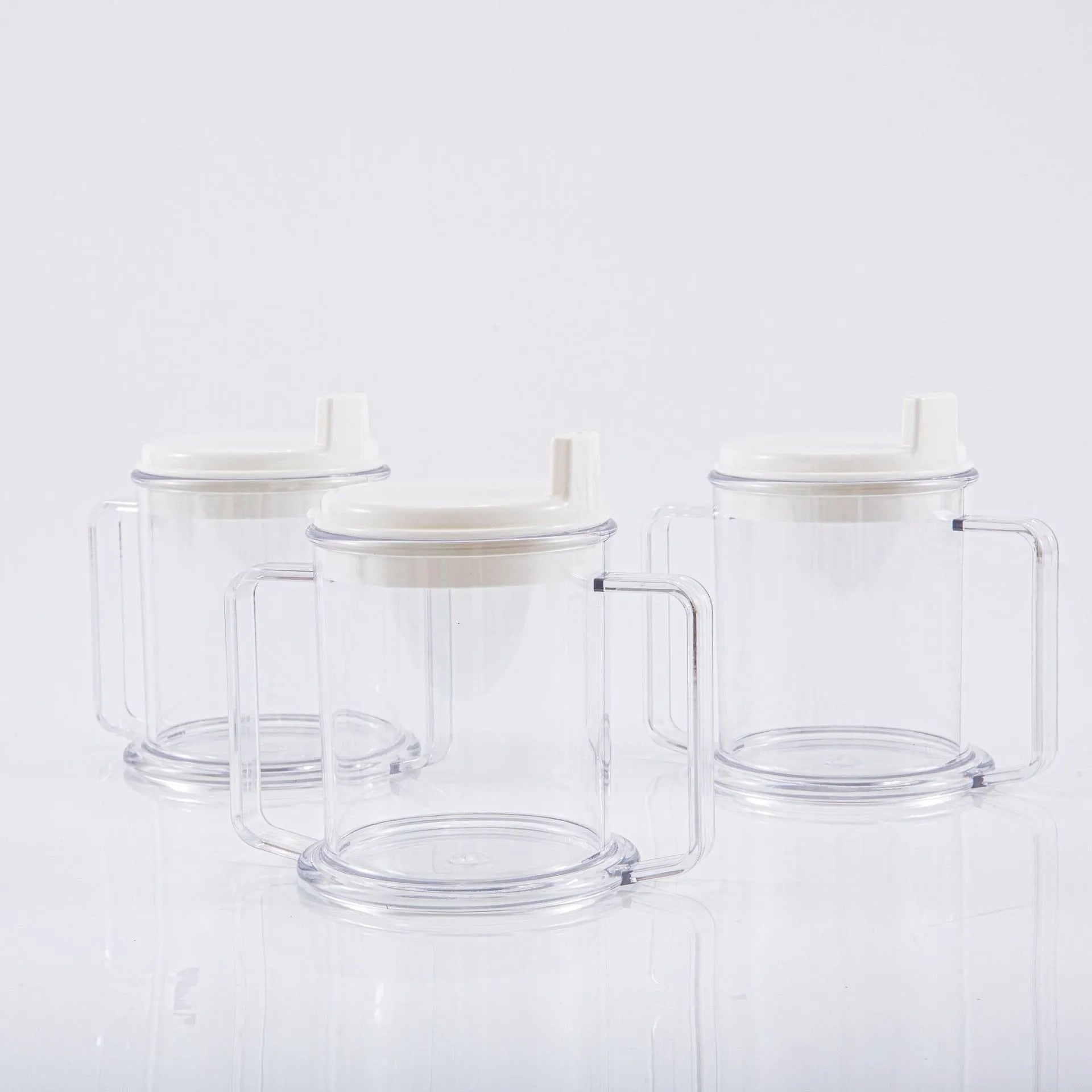 Transparent plastic drinking cup with a lid on a solid background.