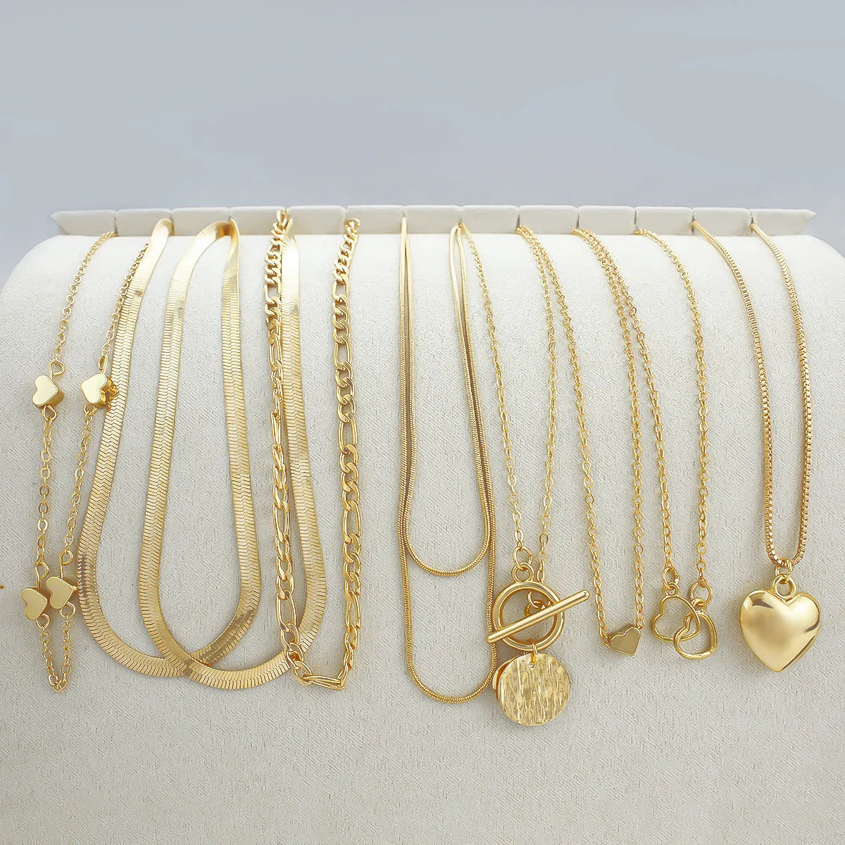 10 piece gold electroplated women's necklace set with adjustable chain length on display