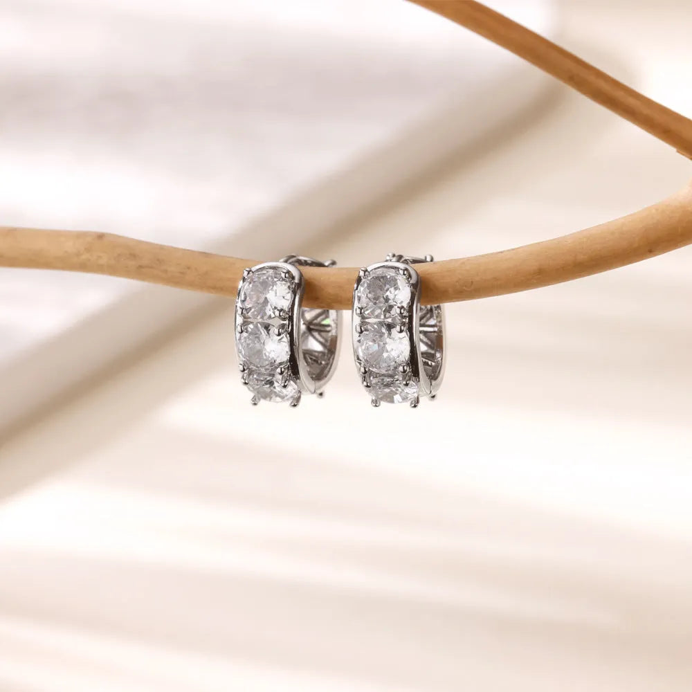 Women's silver-tone U-shaped clip earrings with small sparkling zircon stone details on a white background.