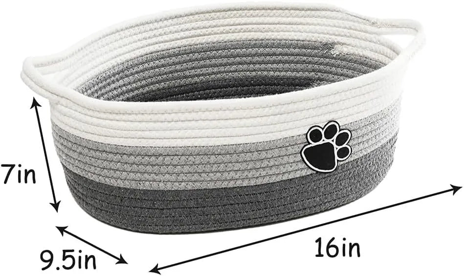 Handmade light beige woven cotton rope storage basket with a handle, shown on a wooden surface.
