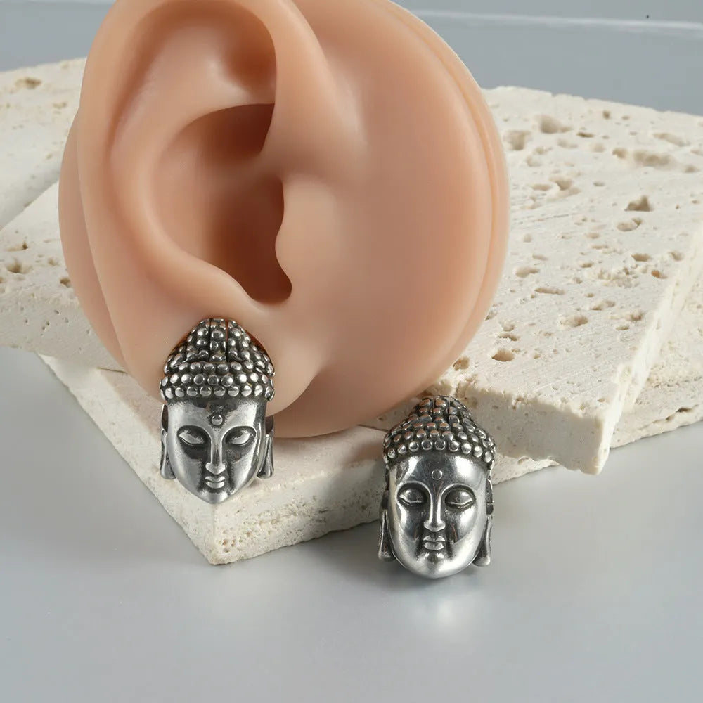 Stainless steel hollow skull Buddha earring for auricle piercing in hip hop style.