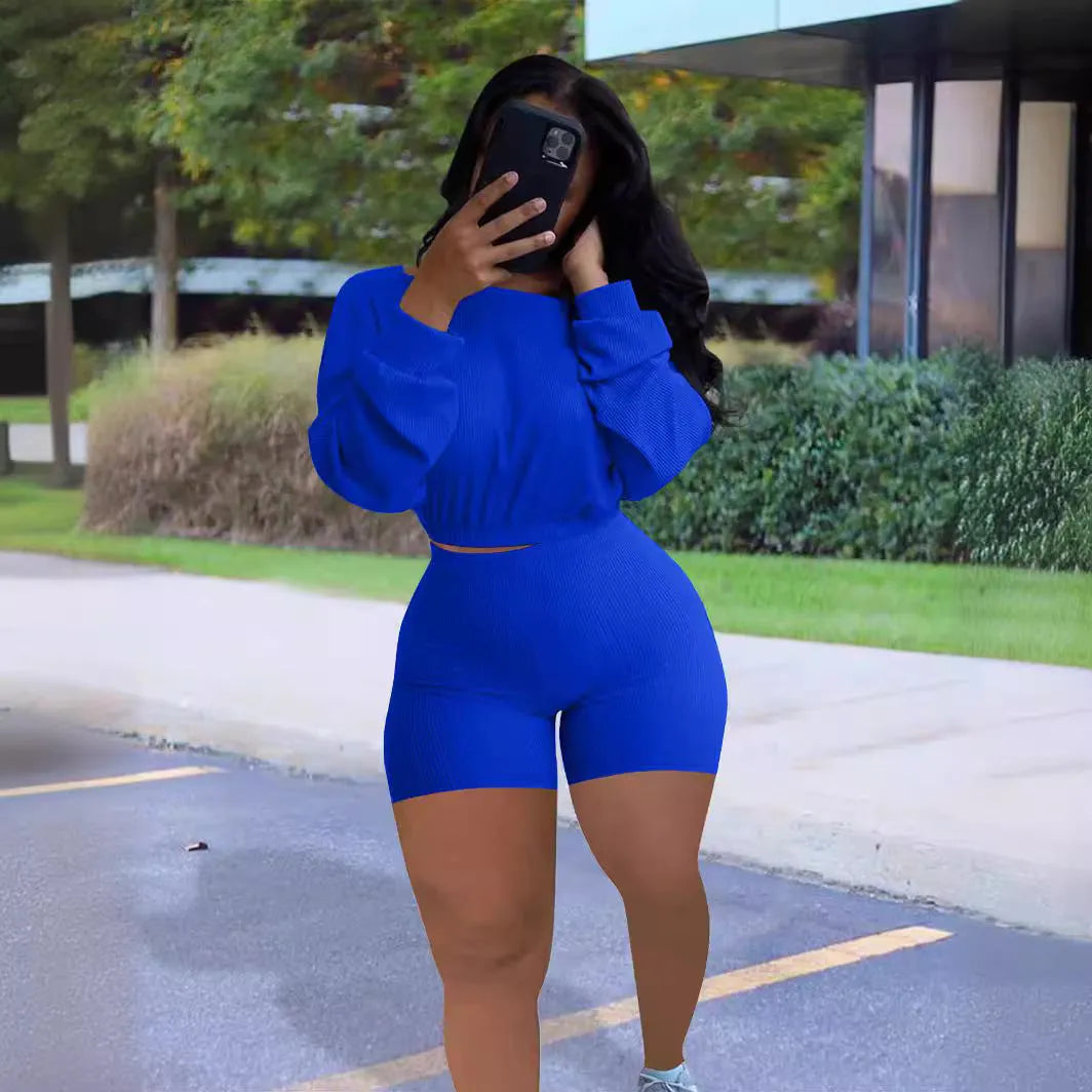 Women's off-the-shoulder long sleeve top and shorts two-piece set in a solid colour.