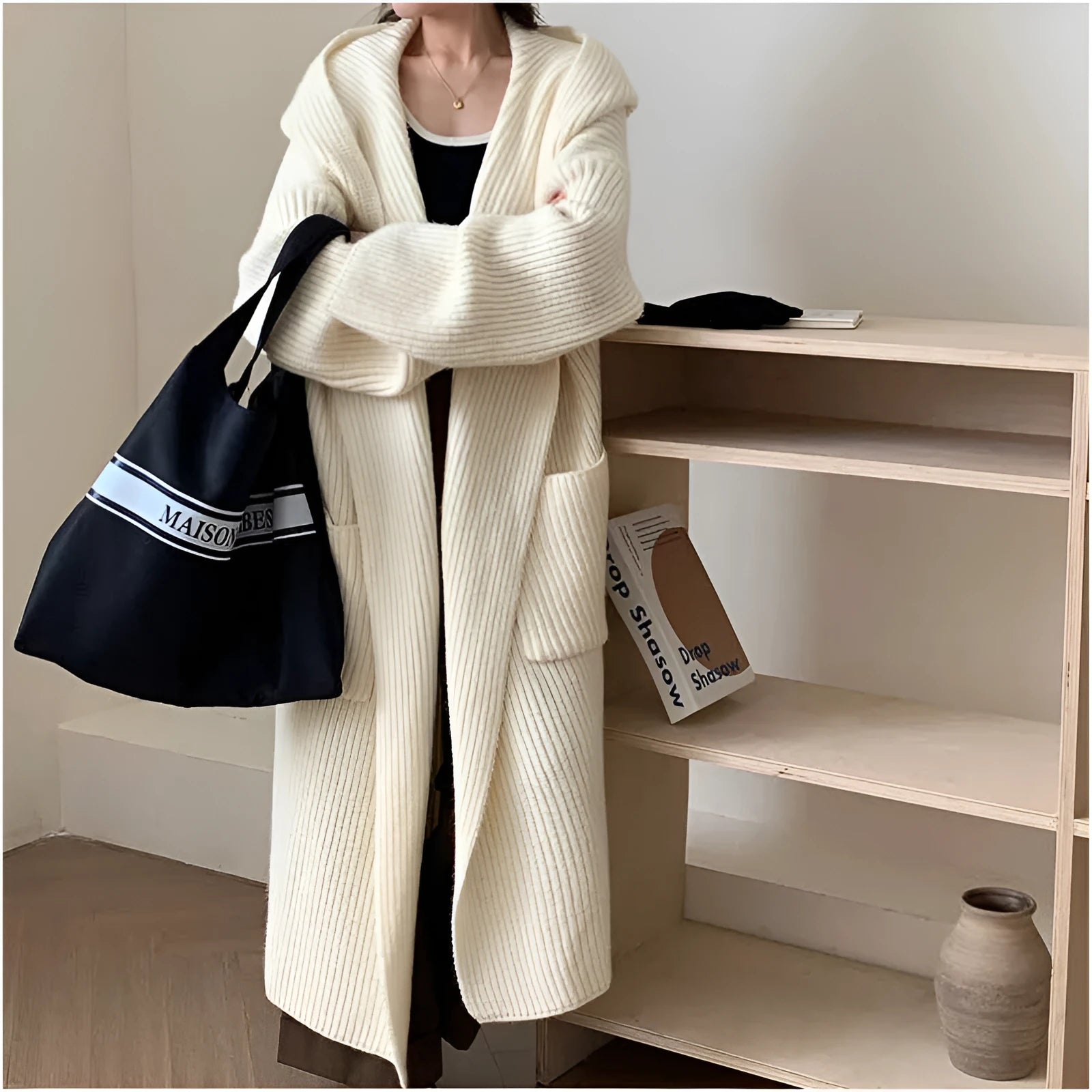 Loose grey hooded cardigan coat with raglan sleeves shown on a hanger.