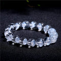 Women's white crystal ghost pyramid bracelet with ruyi charm on a wrist, showing bead detail.