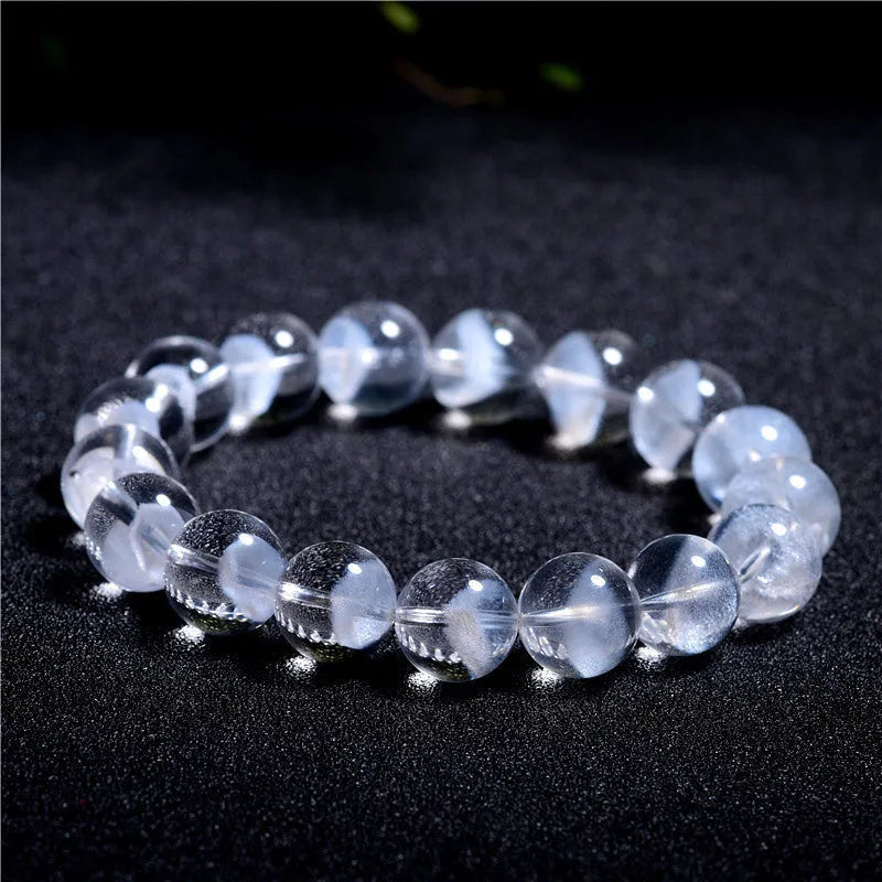 Women's white crystal ghost pyramid bracelet with ruyi charm on a wrist, showing bead detail.