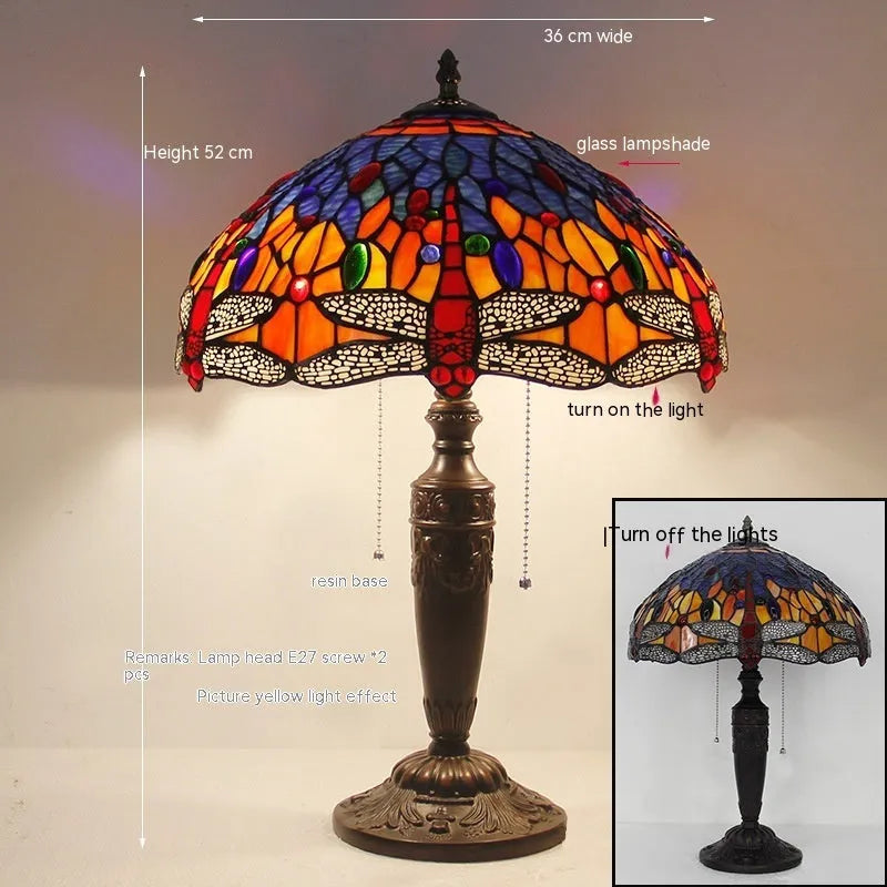 Tiffany style stone table lamp with blue dragonfly design on a bedside table.