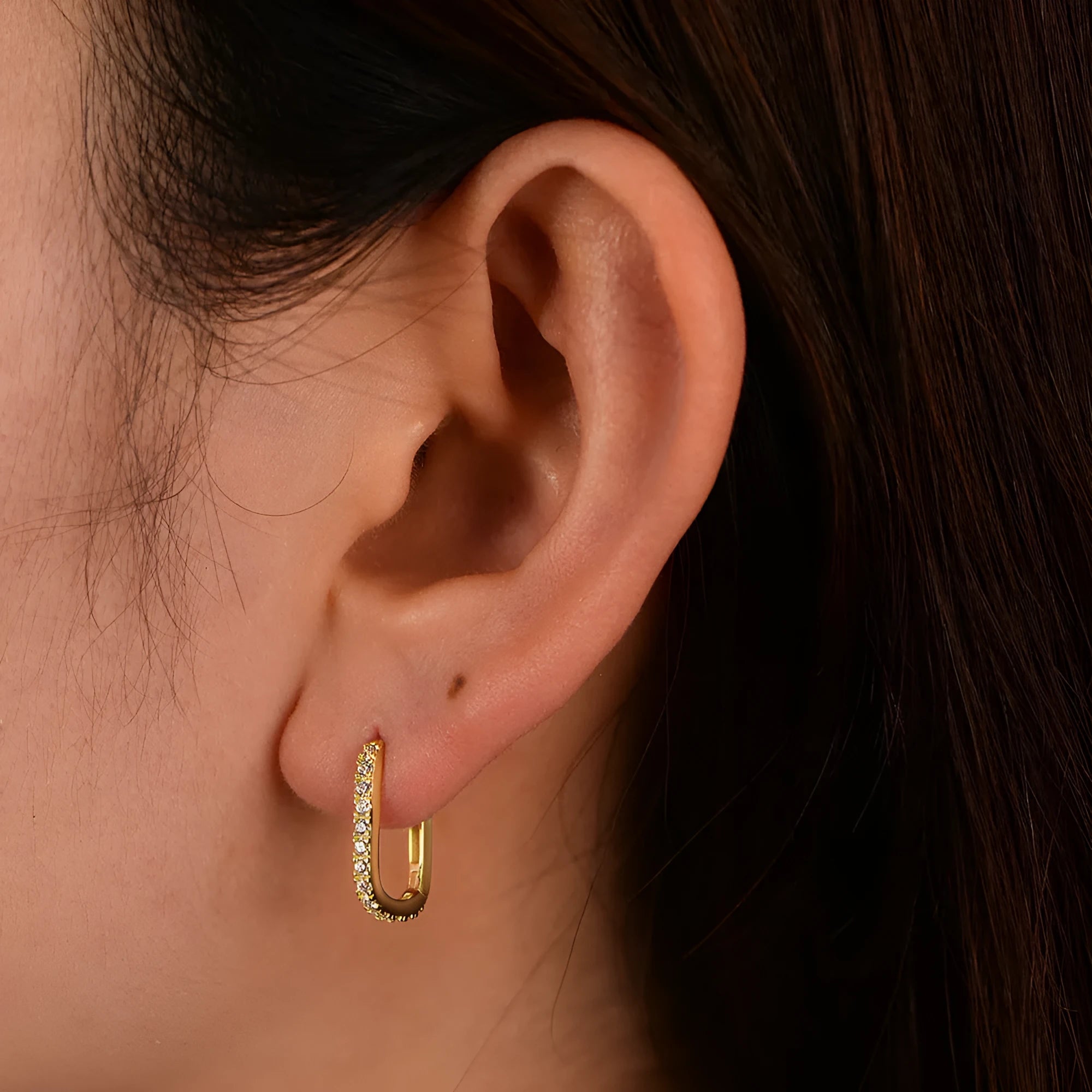 Close-up of a women's sterling silver earring featuring an oval-cut zircon stone.
