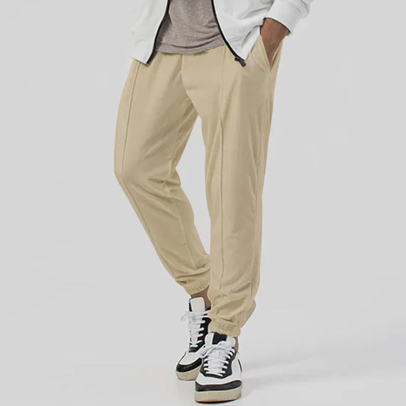 Man wearing grey loose tapered track sweatpants with a casual top