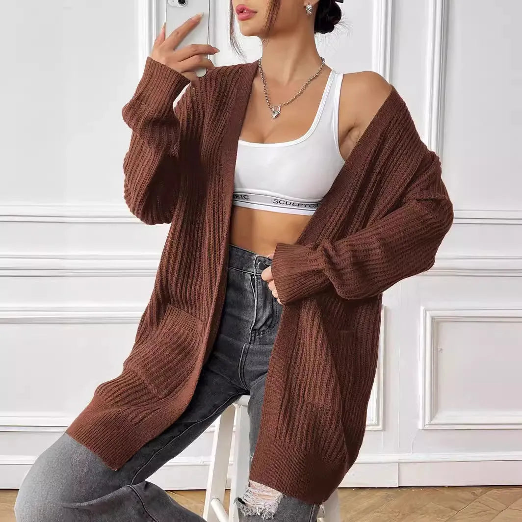 Women's dark green loose-fit cardigan with two front pockets and long sleeves.