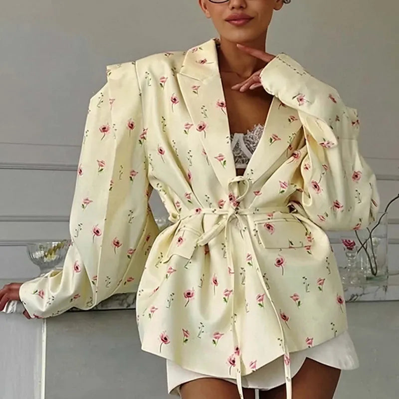Women's floral print suit jacket with lace-up waist closure on a hanger.