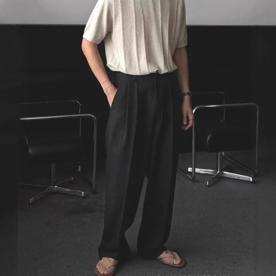 Man wearing apricot-coloured wide-leg cotton linen suit trousers with a pencil leg opening.