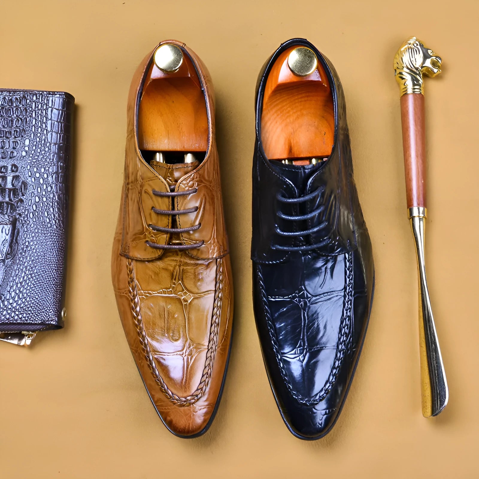 Men's black leather formal shoes with alligator pattern texture and a horse bit buckle detail.