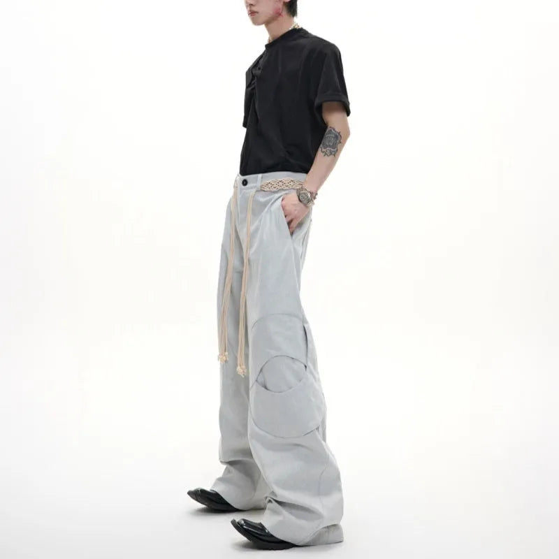 Men's dark blue straight-leg cotton jeans showing 3D cutting, belt stitching, and zipper pocket details.