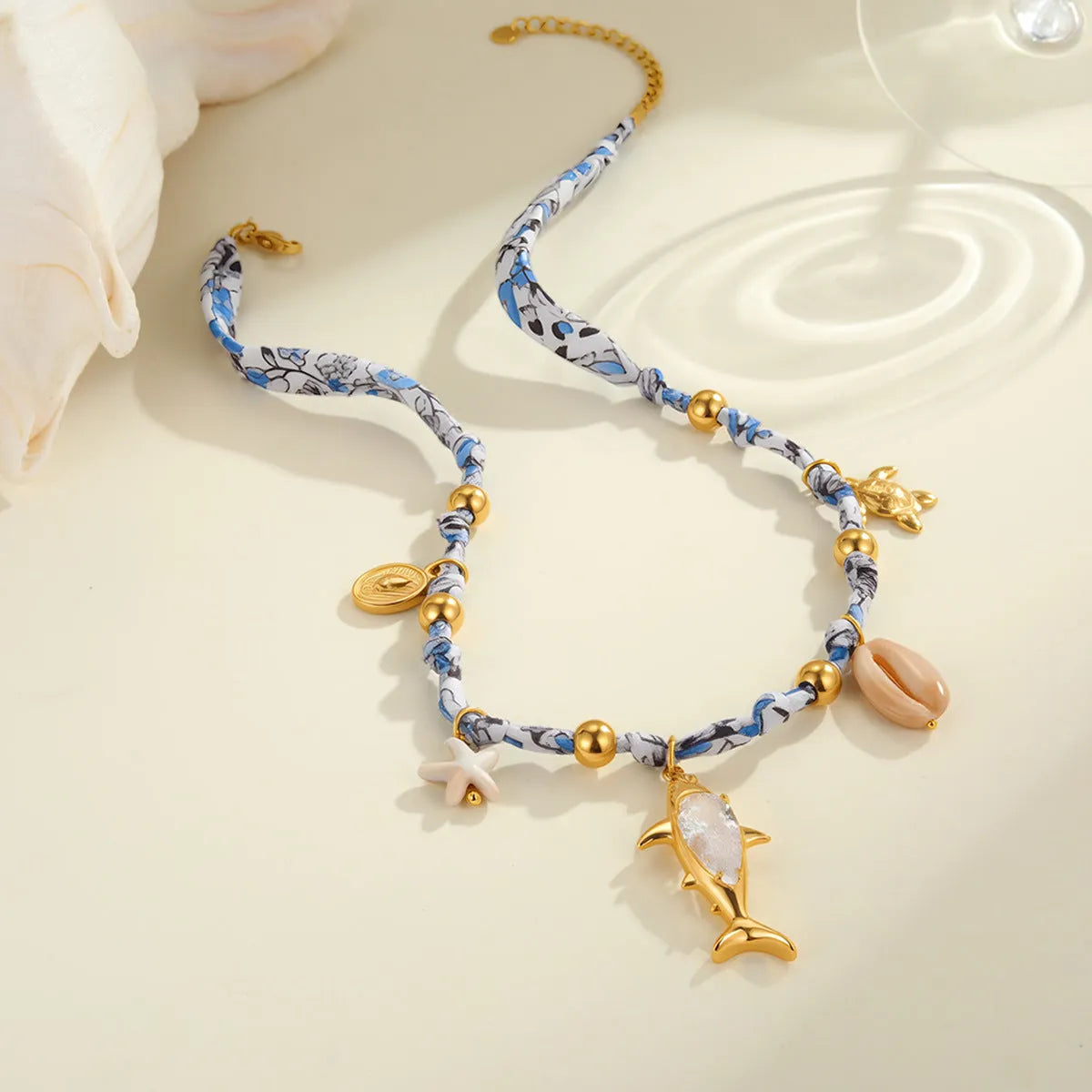 Gold starfish shell pendant on hand-knotted rope chain, 18K plated stainless steel, geometric shape