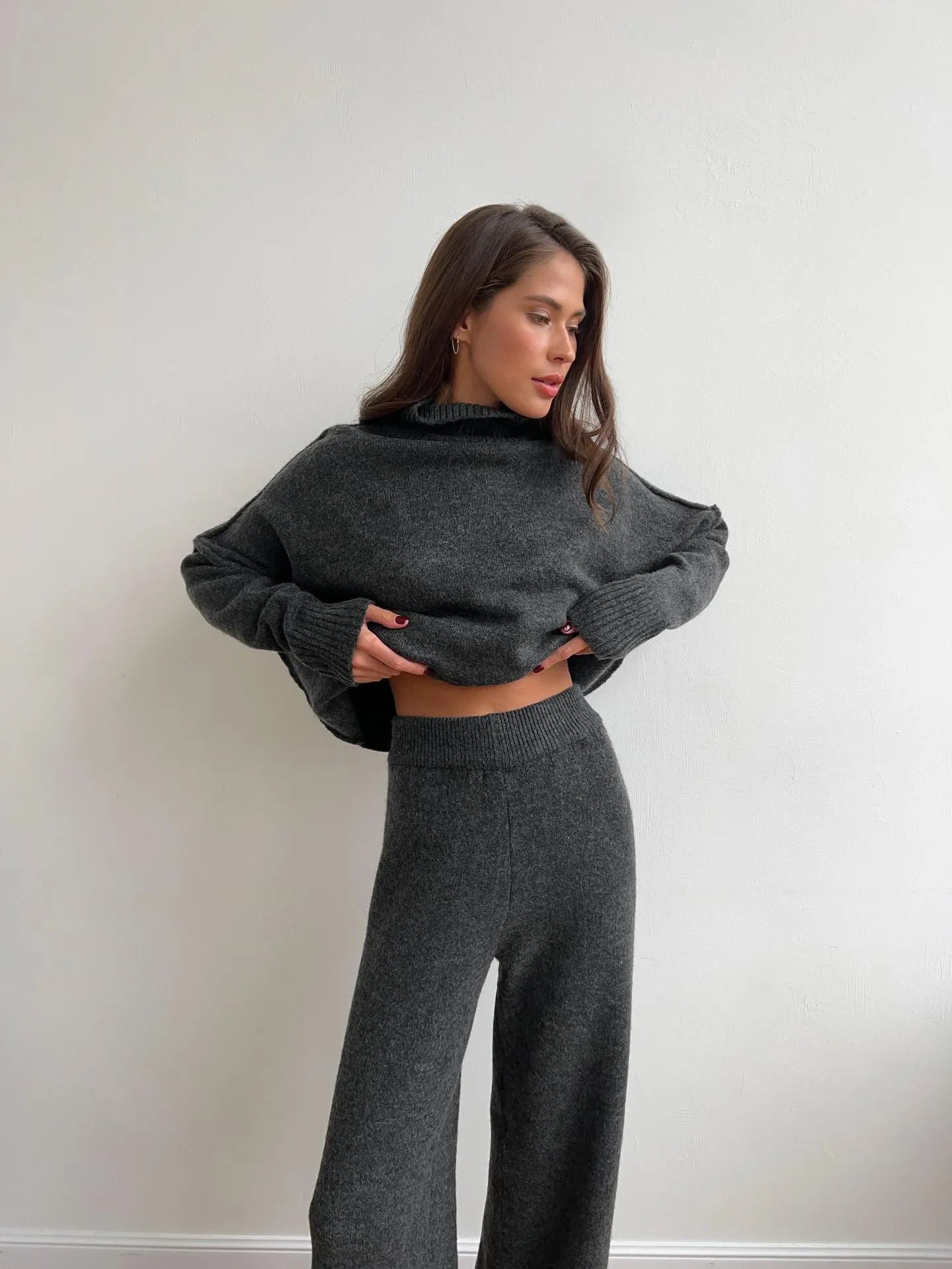Women's acrylic sweater suit with side-slit top and trousers in dark grey.