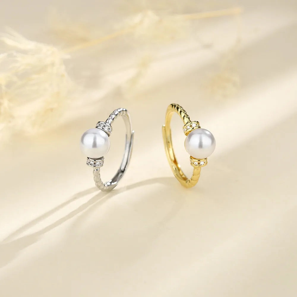 Adjustable antique twist design copper ring with pearl inlay in gold colour.