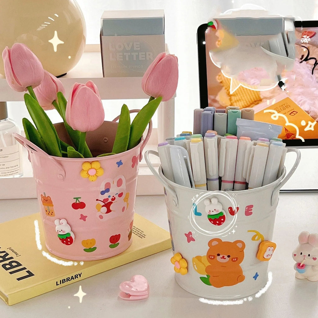 Round metal pen holder in choice of colours with optional decorative sticker patches on a desk.