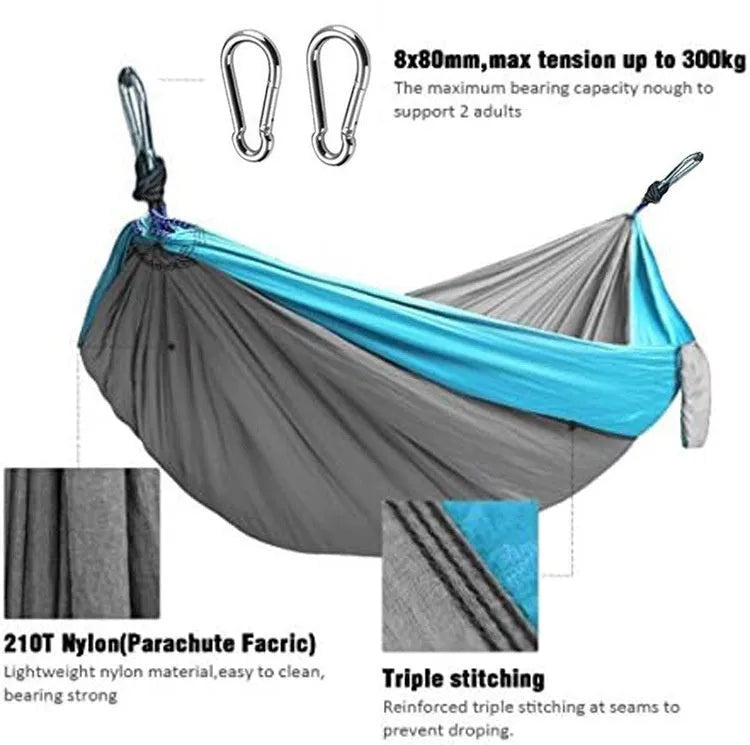Blue nylon camping hammock hanging between trees with parachute fabric construction
