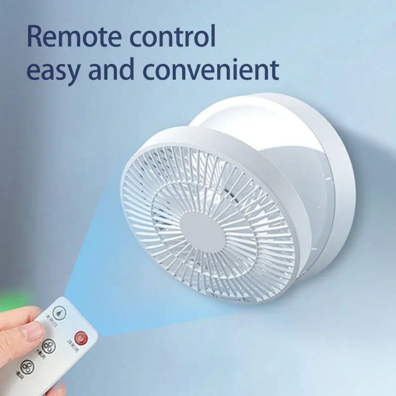 White portable USB folding desk fan with remote control and warm night light on a table.