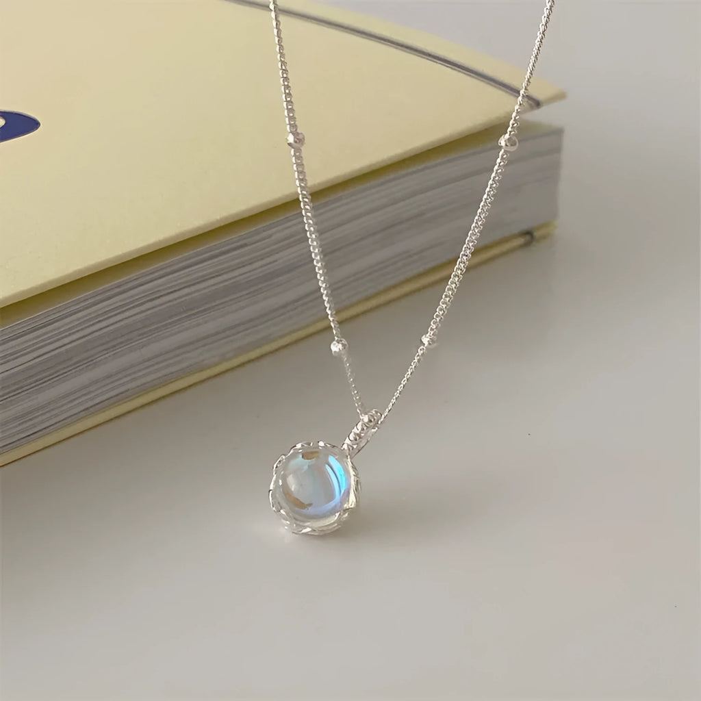 Silver geometric ornamental stone pendant on a curb chain necklace for women.