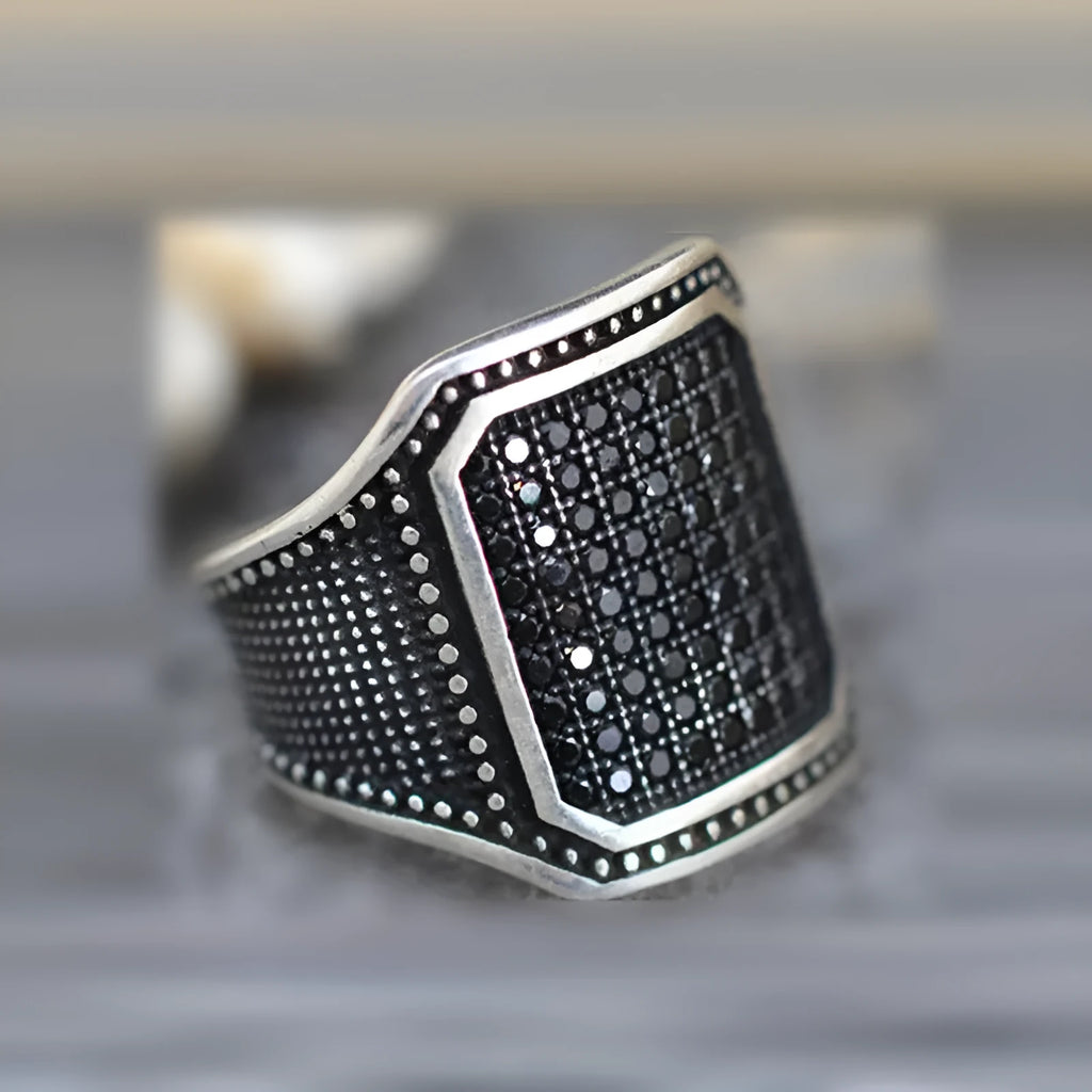 Unisex black alloy ring with copper inlay and a zircon stone.