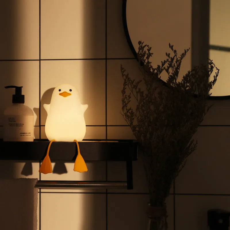 Seagull silicone night light in yellow colour with soft warm glow on bedside table