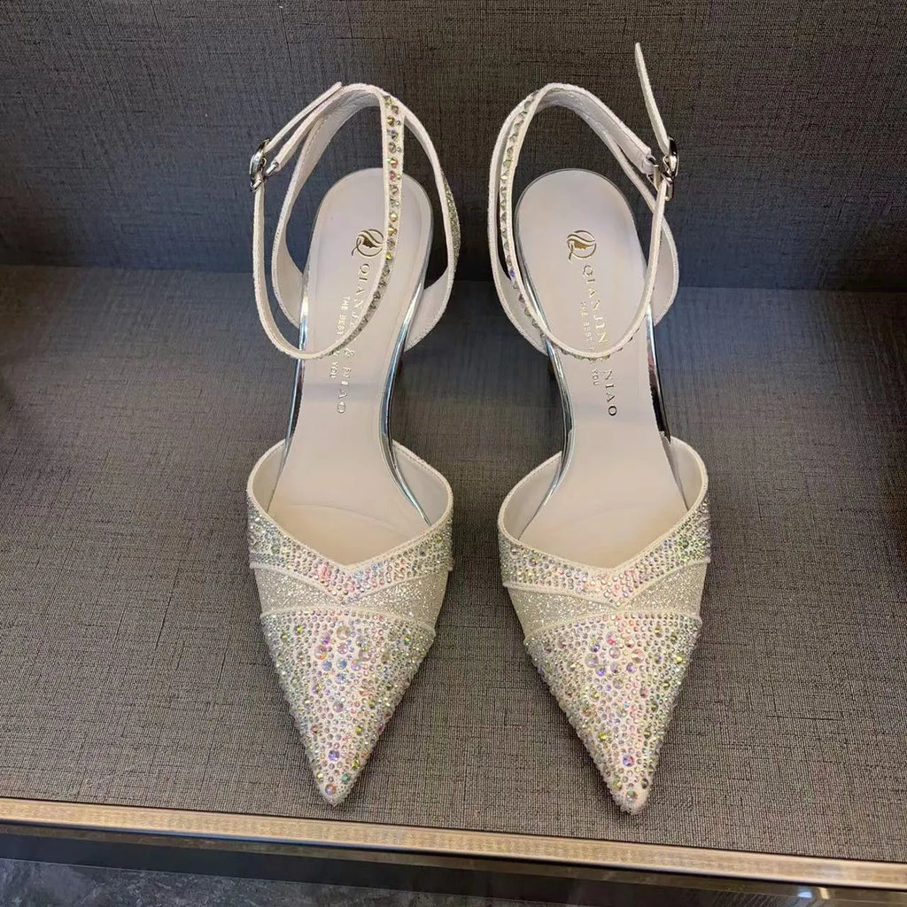 Women's black pointed toe high heels with a hollow stiletto heel and red sole, shown from the side.