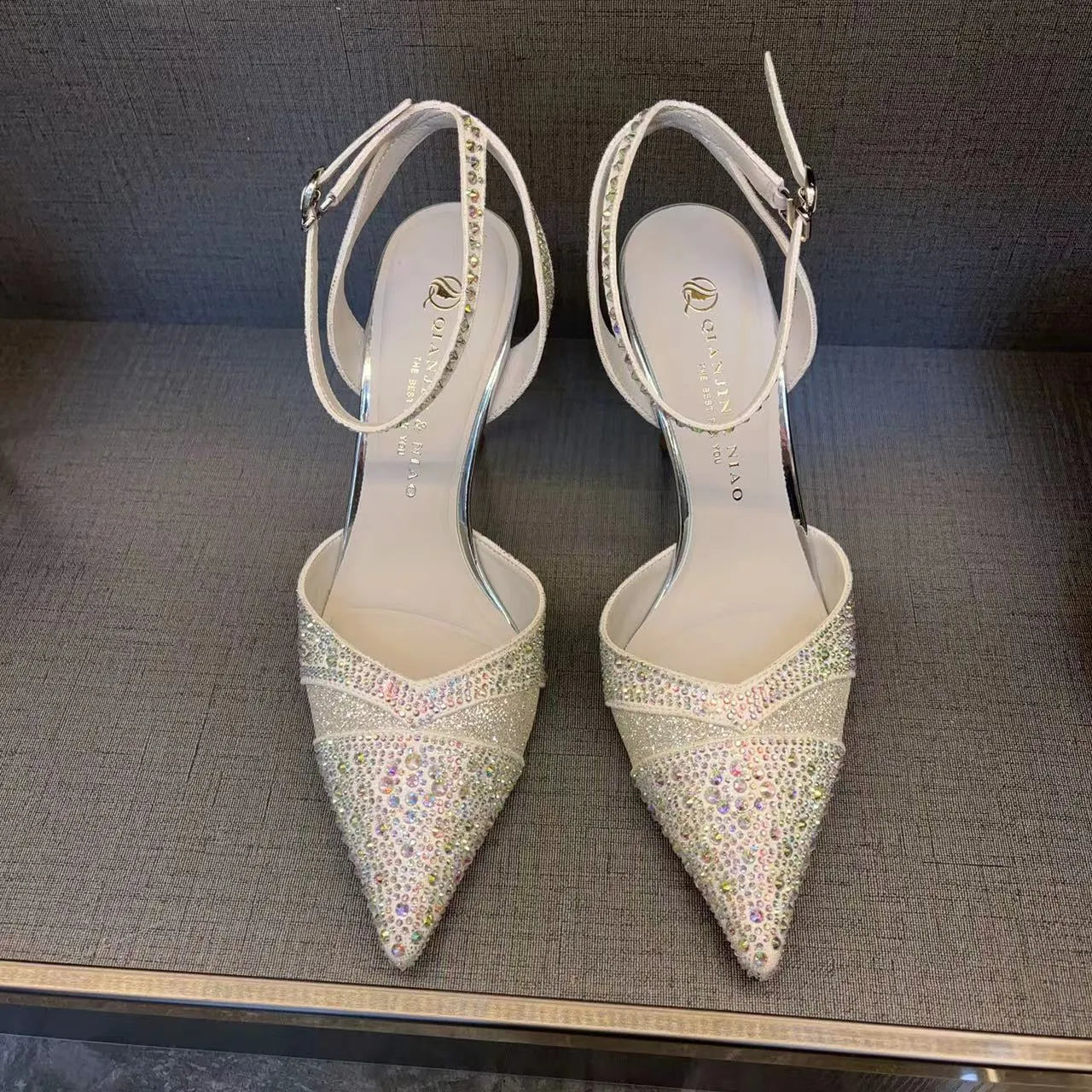 Women's black pointed toe high heels with a hollow stiletto heel and red sole, shown from the side.