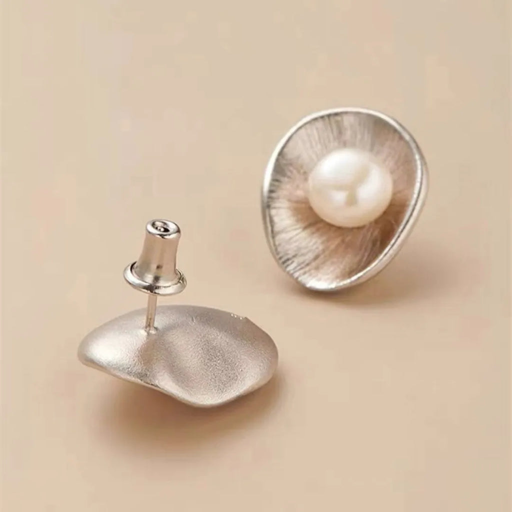 Gold electroplated sterling silver pearl ear studs with geometric design and surgical steel posts